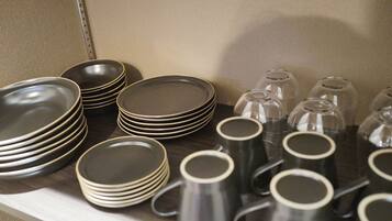 A display of stacked plates and mugs on a shelf.