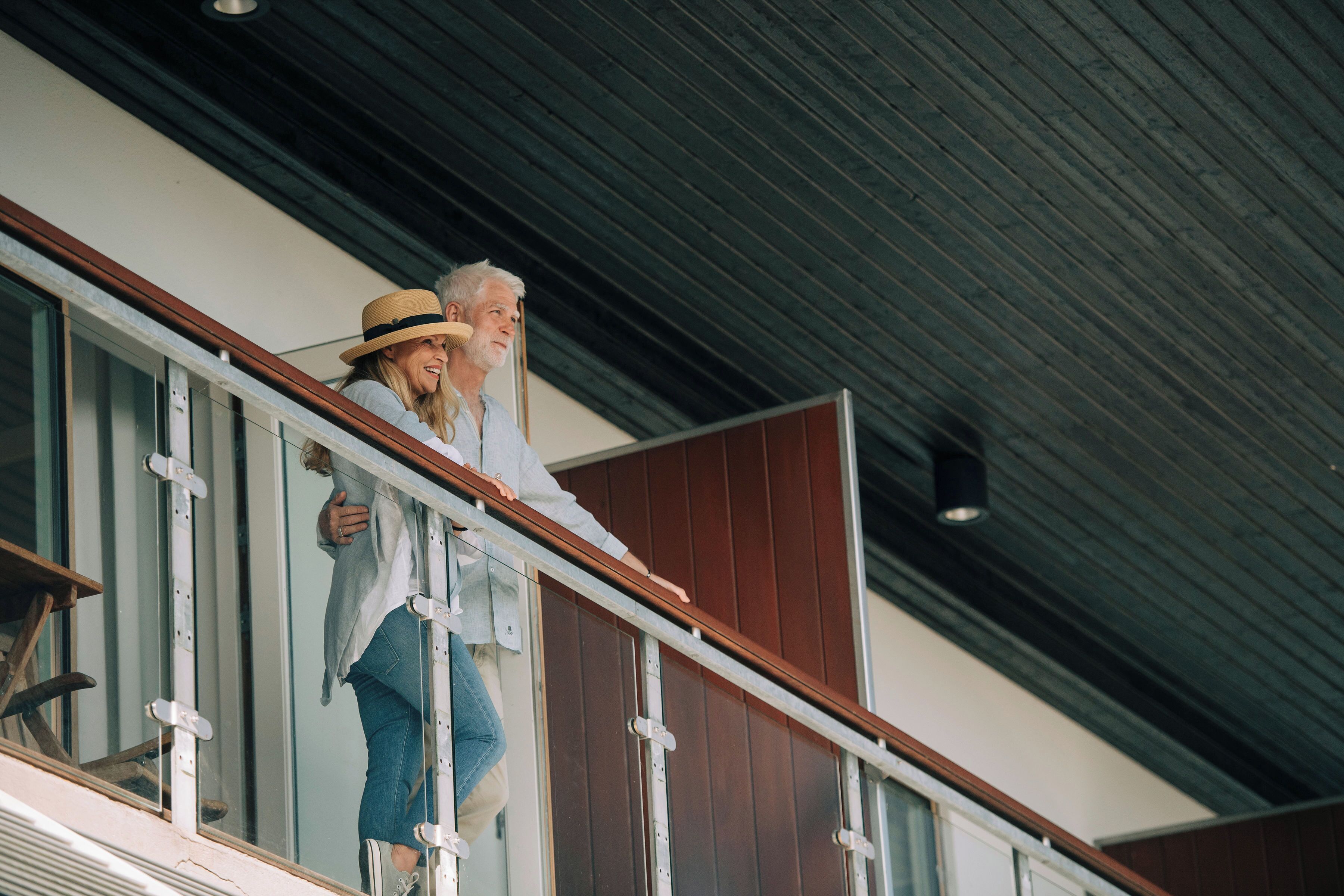 A person standing on a balcony with a view of the building's interior and exterior.