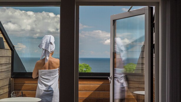 A spa room with a wooden deck and a large window overlooking the sea. - Kiviks Hotell Konferens och Spa (Kivik)