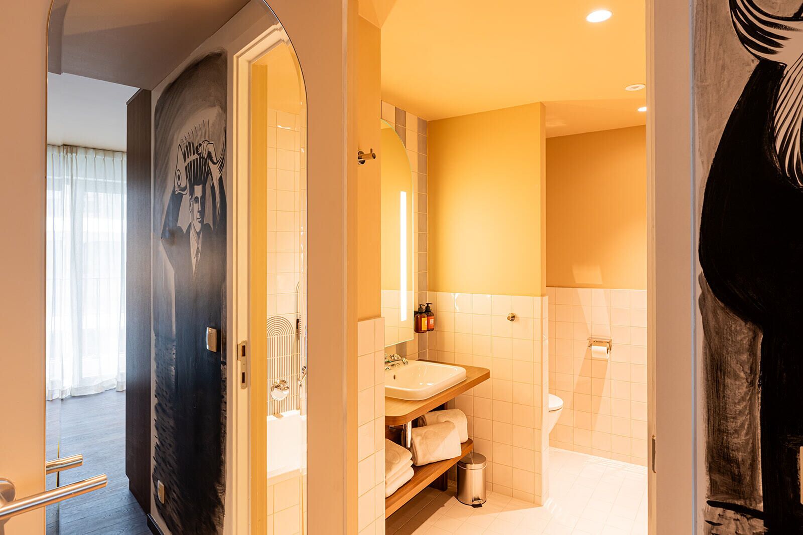 Une salle de bain moderne avec un lavabo, un miroir et un porte-serviettes.
