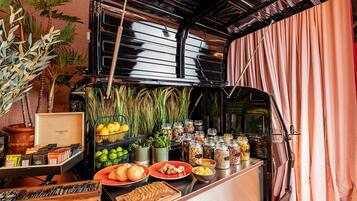 A kitchen counter with various food items, including fruits, vegetables, and jars of spices.