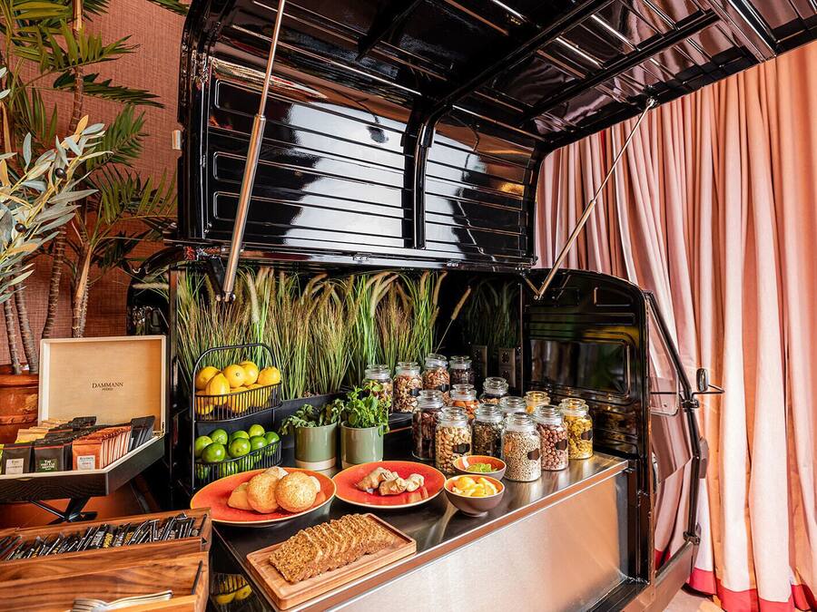 A kitchen counter with various food items, including fruits, vegetables, and jars of spices.