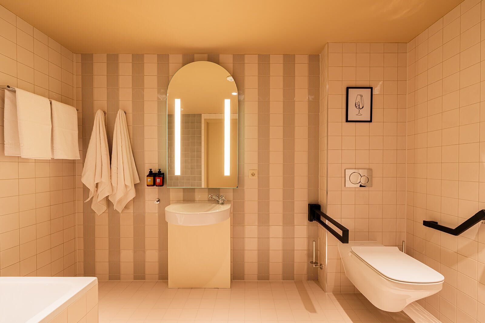 A bathroom with a sink, mirror, towel rack, and toilet.