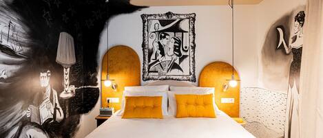 A bedroom with a large bed, two bedside tables, a wall-mounted artwork, and a unique ceiling design.