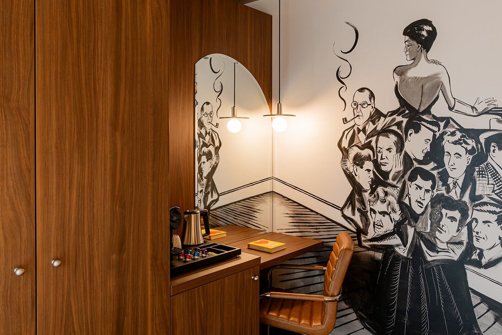 Un coin de pièce avec un meuble en bois, un bureau avec une lampe et une fresque murale.