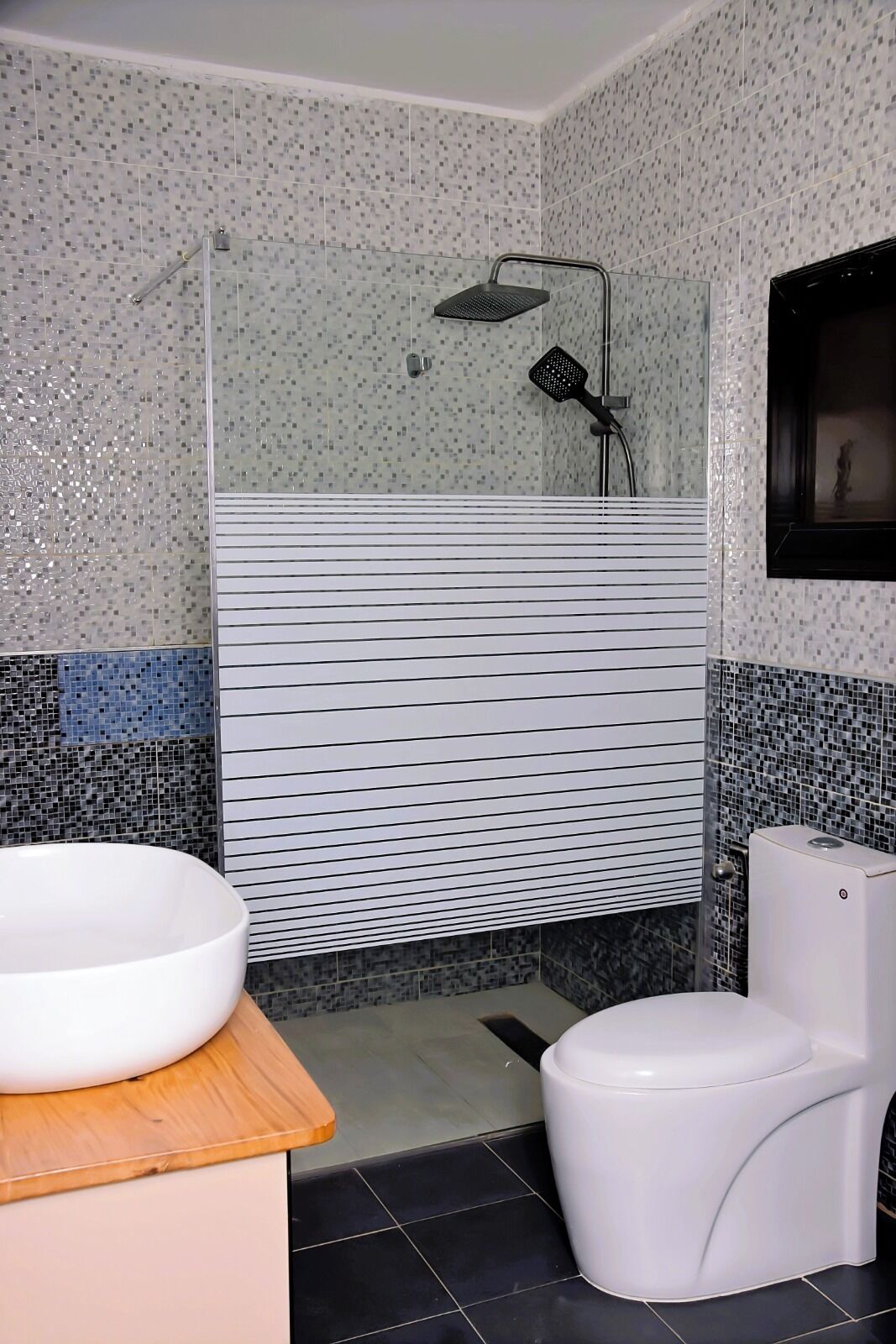 A bathroom with a shower, a toilet, and a sink.