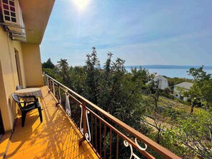 A balcony with a view of the sea, a table, and chairs. - Apartment Niro (Crikvenica)