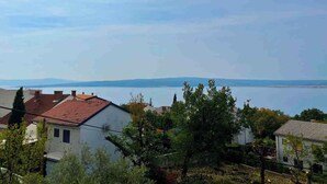 Un quartier résidentiel avec des maisons, des arbres et une étendue d’eau en arrière-plan.