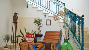 Uma escadaria com grades azuis, uma placa de pare e várias plantas.