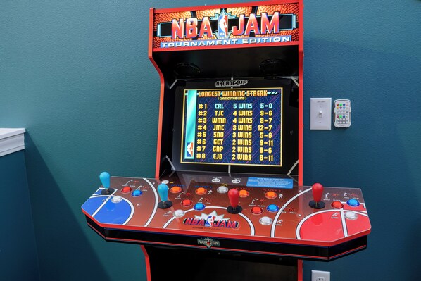 Eine Spielautomat mit Basketball-Motto, inklusive Punktestand und mehreren Joysticks.