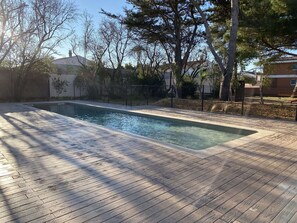 Relax by the pool surrounded by lush greenery and a scenic view.