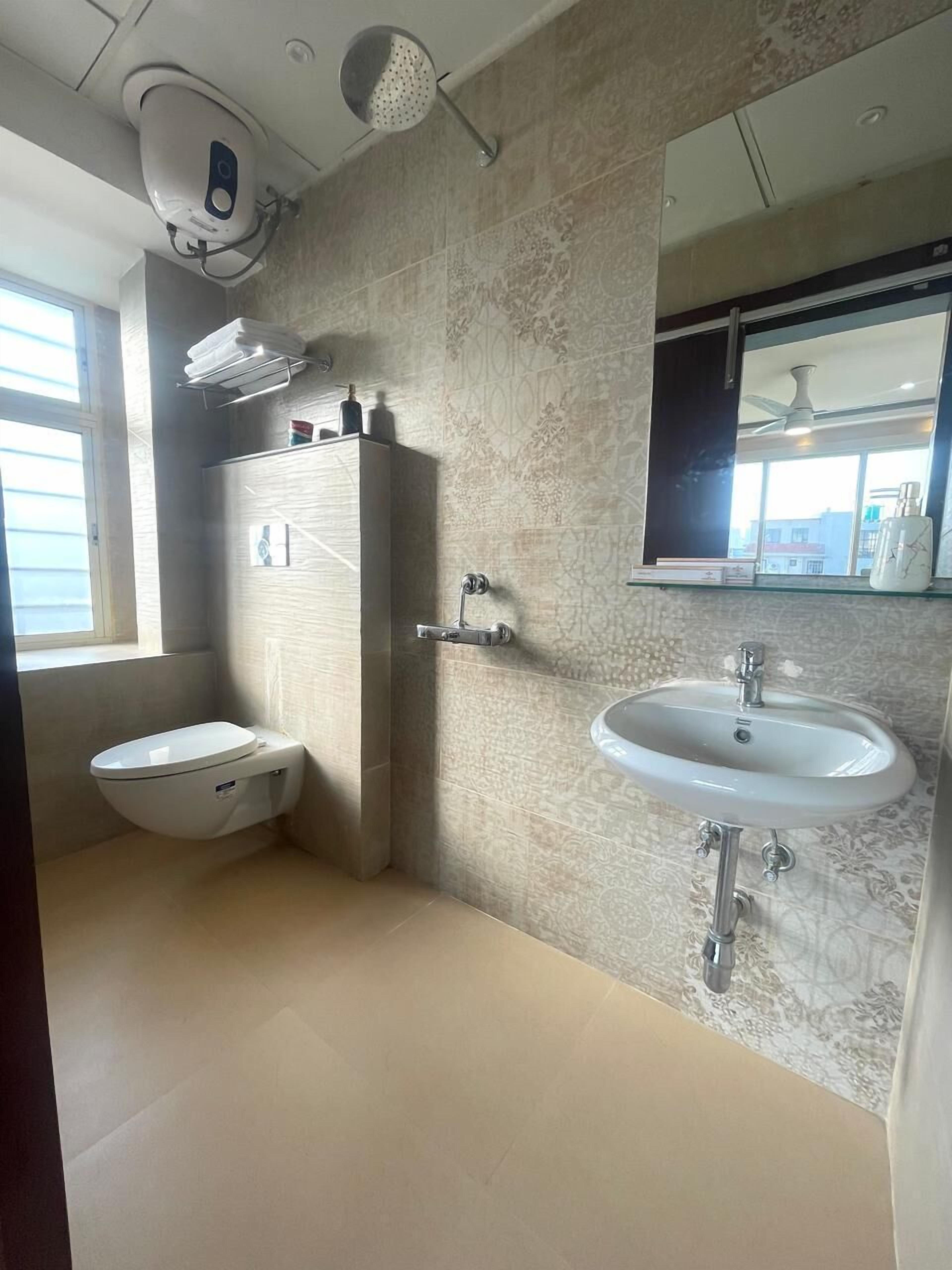 A modern bathroom with a toilet, sink, and shower.