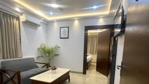 A modern living room with a sofa, a coffee table, and a ceiling fan. - The Crystal Newtown Kolkata (Barasat)
