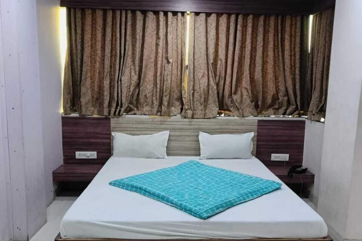 Un dormitorio con cama, cortinas, ventilador de techo y mesita de noche.