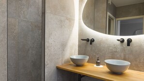 A modern bathroom with a large mirror, two sinks, and a towel rack. - Ma.maison (Guémar)
