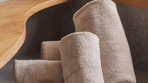 A set of rolled towels on a shelf in a bathroom. - Ma.maison (Guémar)