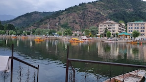 Vista del río con barcos, un puente y edificios al fondo.