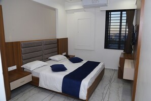 Une chambre à coucher bien rangée, avec un lit, des tables de chevet, une armoire et une fenêtre donnant sur un beau paysage.