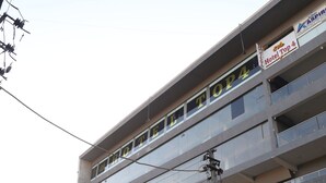 A multi-story building with various shops on the ground floor and a hotel named "Hotel Top 4" on the upper floors.