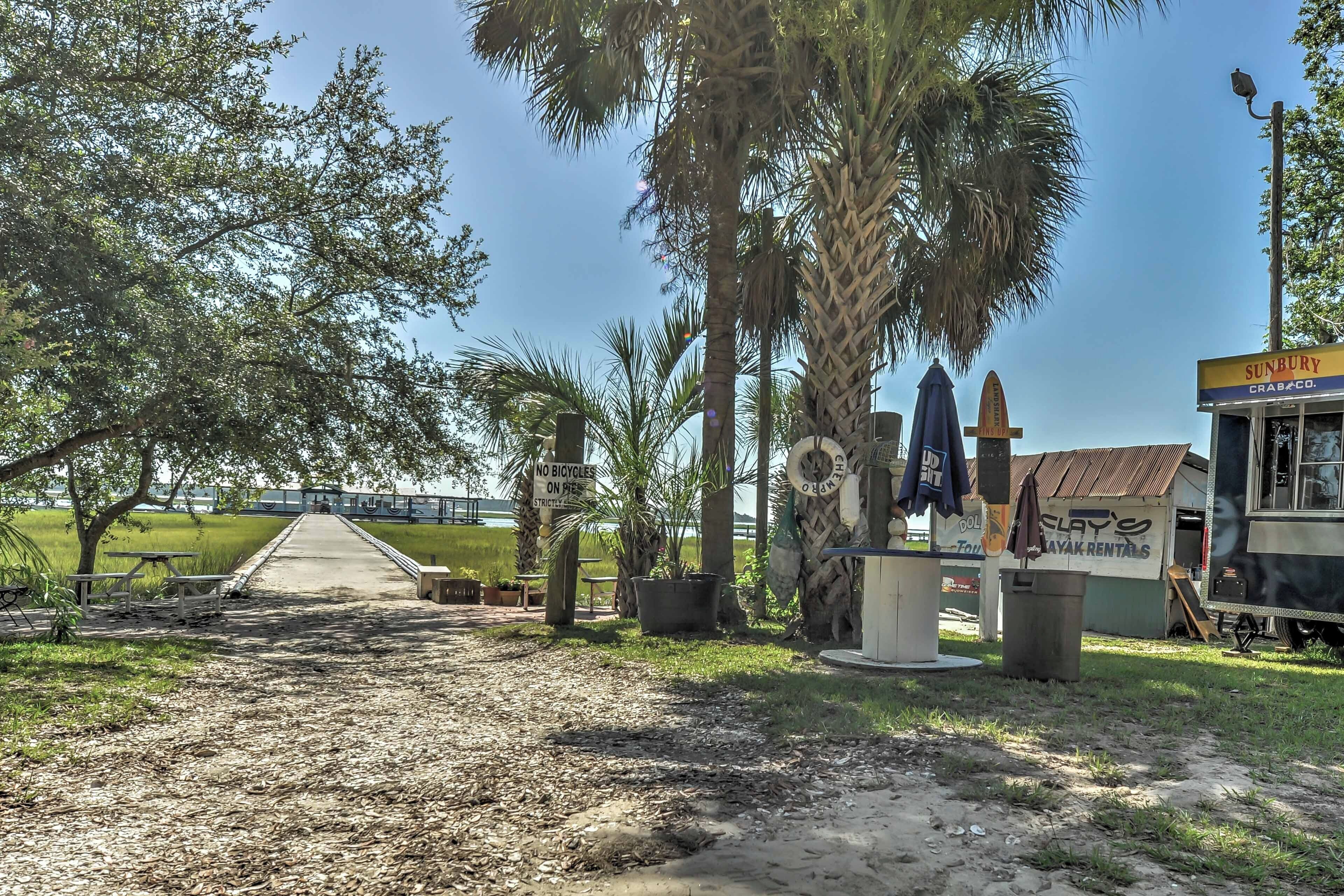 A pathway leading to a building with a sign that reads "SUNBURY CRAB CO." and another sign that says "NO BICYCLES ON PAVEMENT."