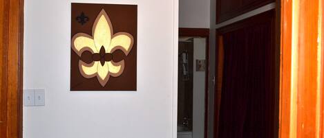 A wall-mounted fleur-de-lis symbol on a white wall.