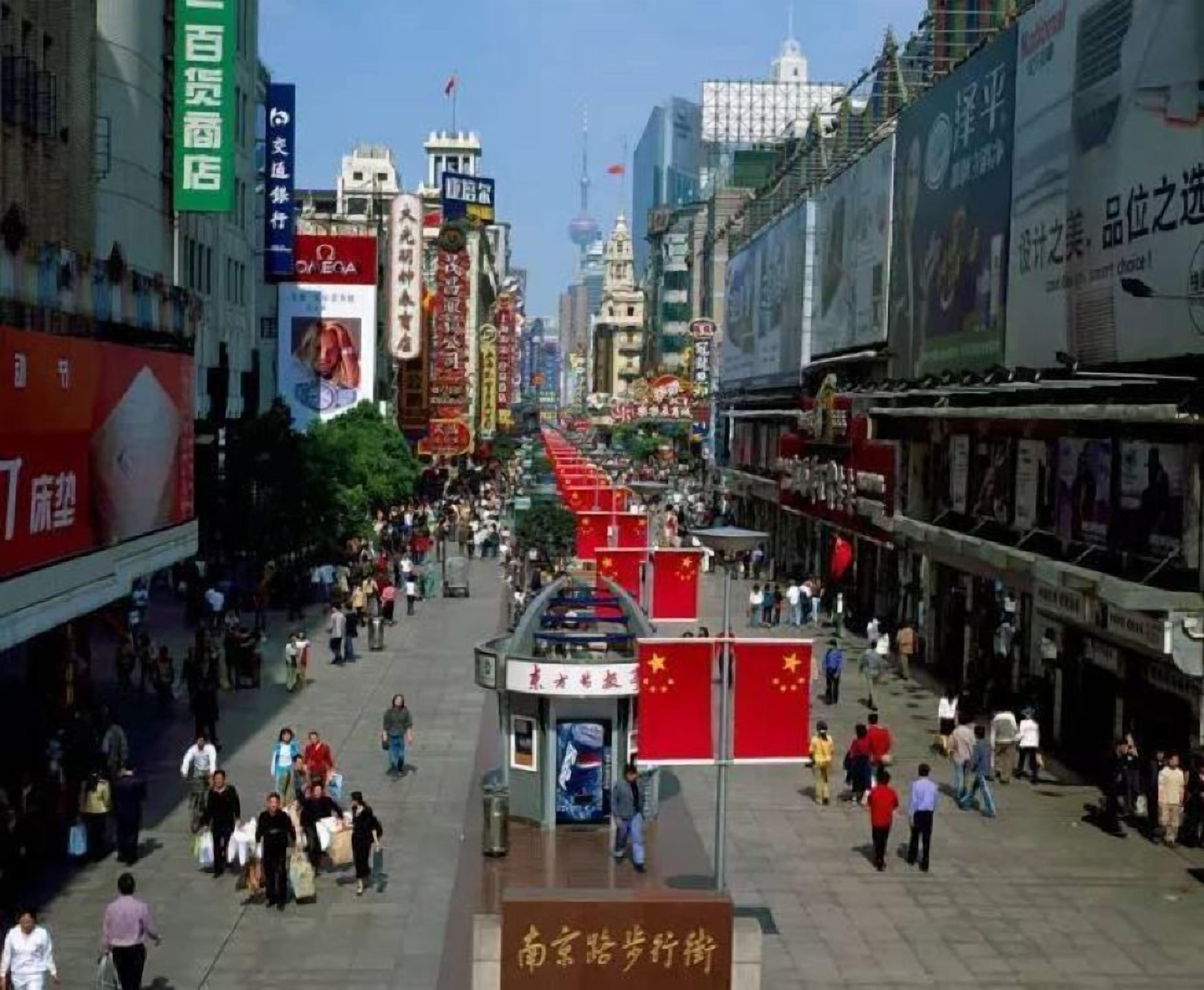 A busy urban street with various shops and advertisements.