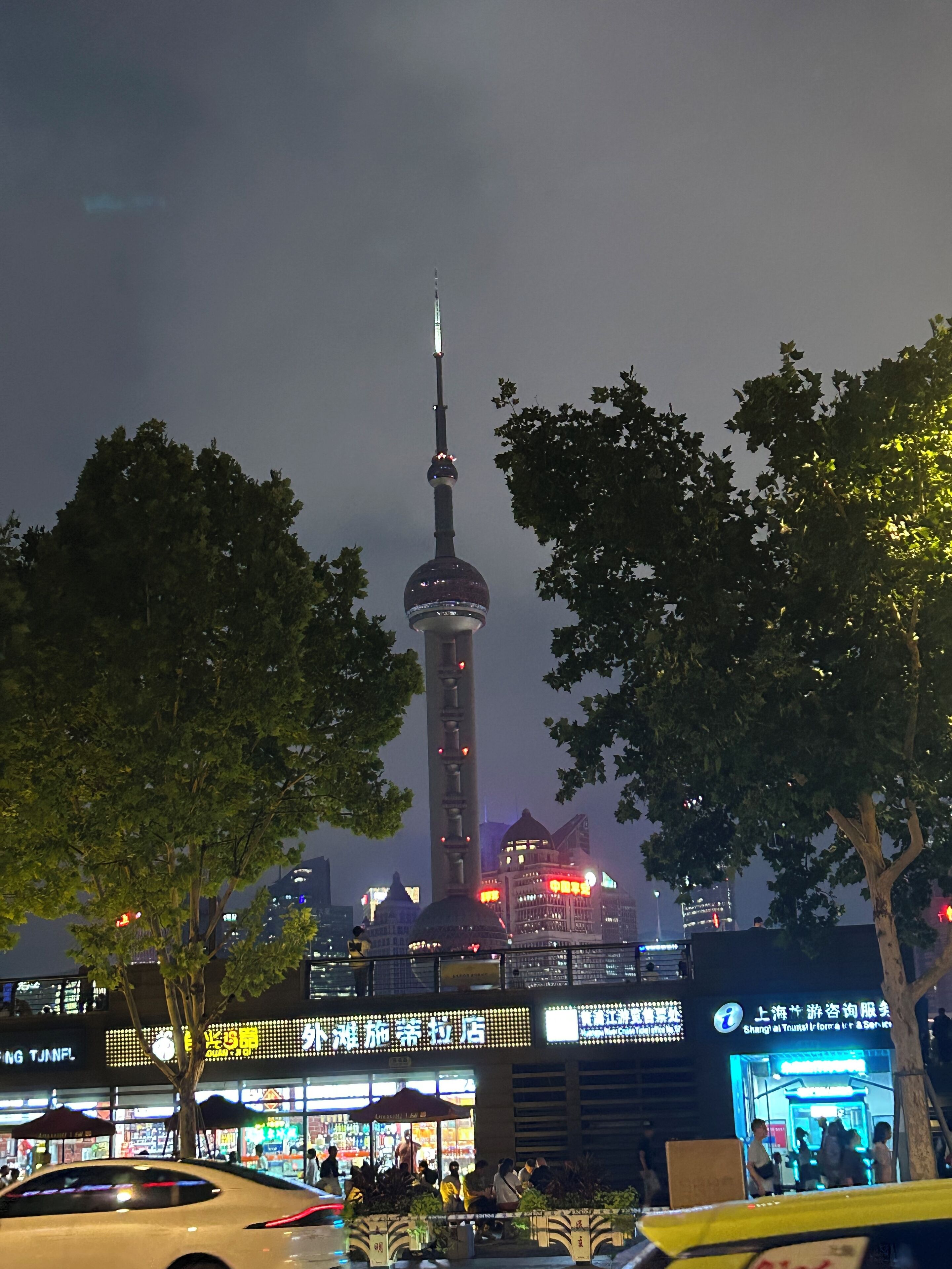 A nighttime cityscape with a prominent tower and surrounding buildings.