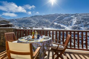 A dining table with chairs on a balcony overlooking a snowy mountain landscape. - Andorra Stunning Views Apartment (El Tarter)