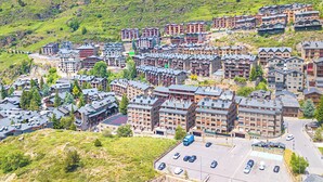 A cluster of multi-story buildings with a parking lot in the foreground. - Andorra Stunning Views Apartment (El Tarter)