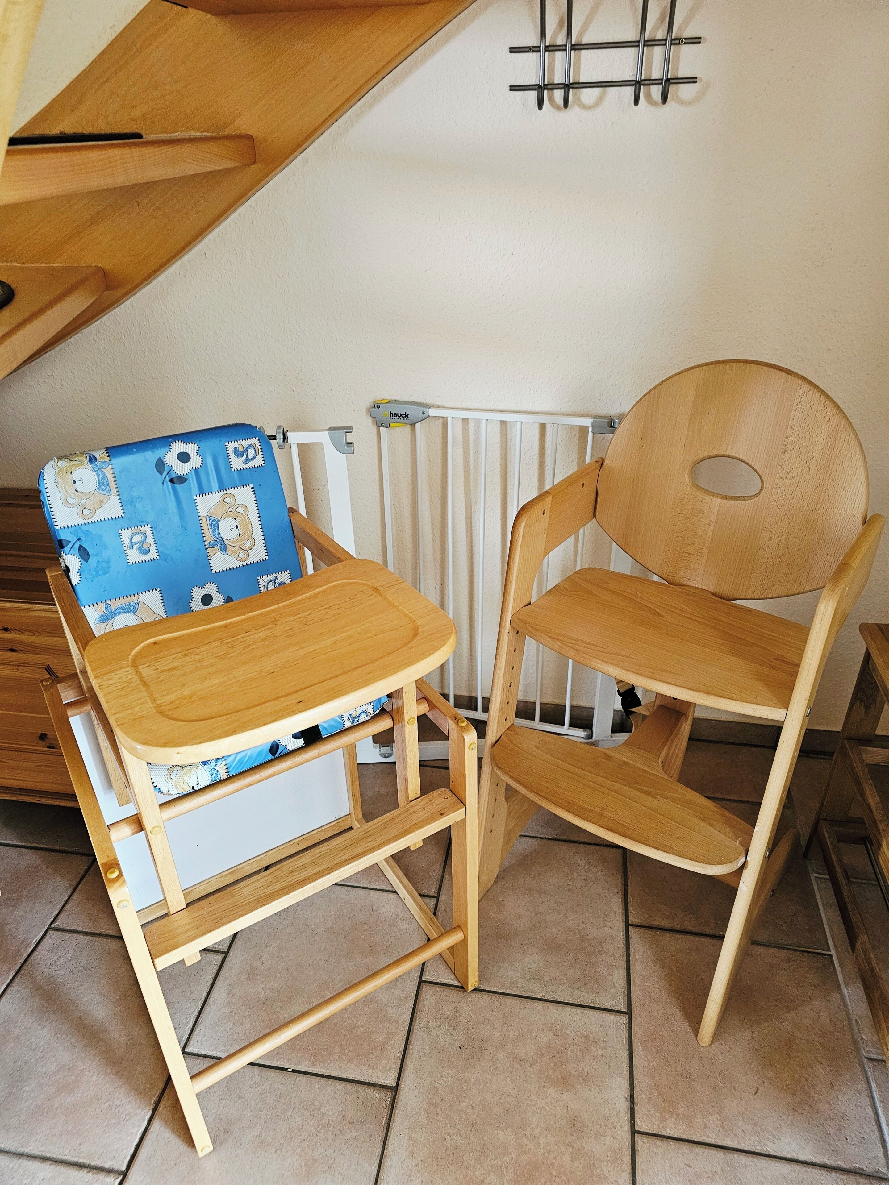 A wooden chair and a small table with a blue patterned cushion, positioned near a white radiator.