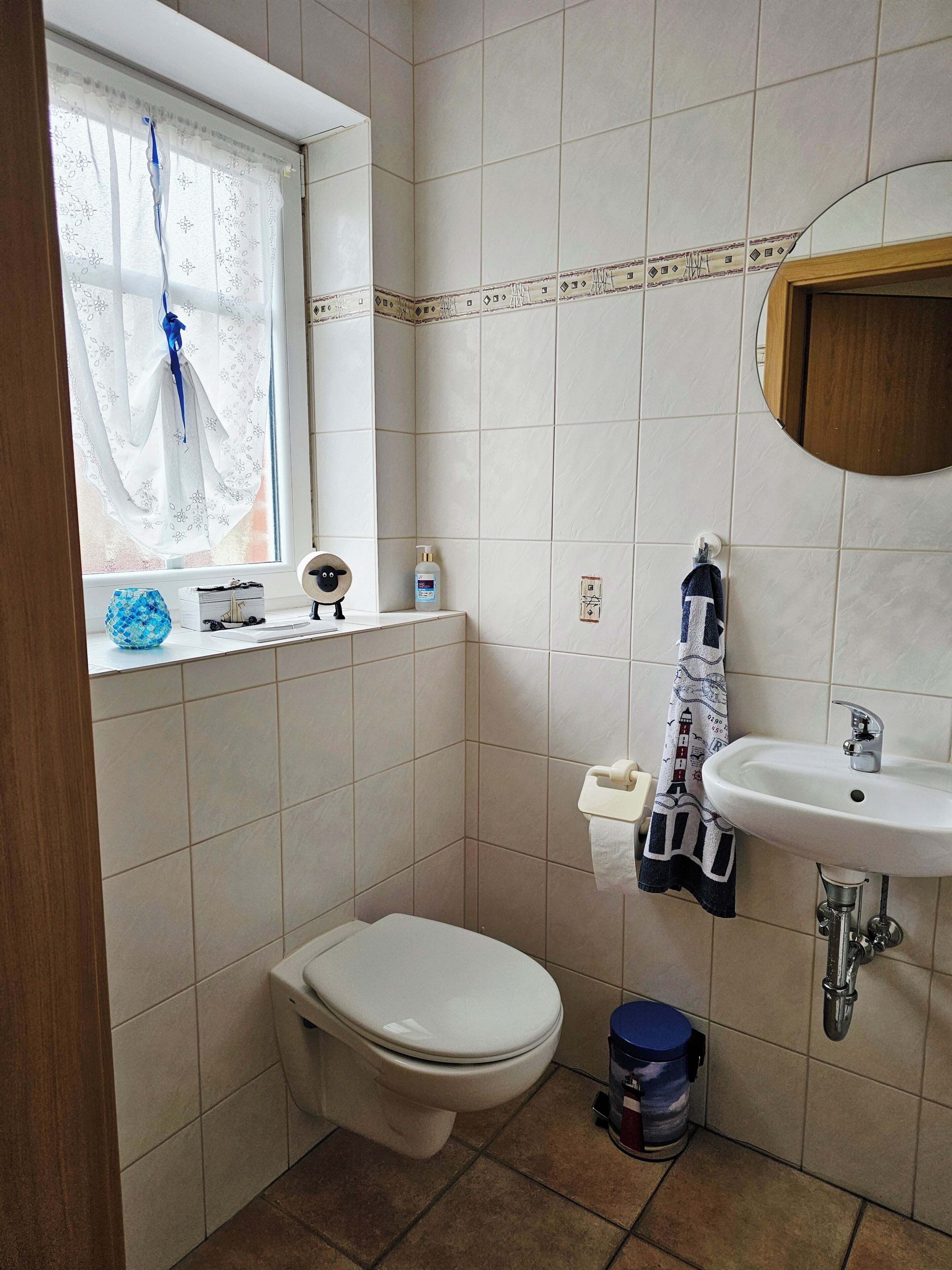 Une petite salle de bain avec des toilettes, un lavabo et une fenêtre.