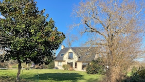 A house with a sloped roof, a visible garage, and a well-maintained lawn. - Spacious and bright house on large plot 10 min walk from Pont L' Abbé (Pont-l'Abbé)