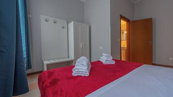 Een hotelkamer met een bed, een kledingkast en een badkamer, zichtbaar door een open deur.