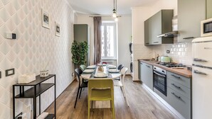 A modern kitchen with a dining area, featuring a central island, built-in appliances, and a view to the dining area.