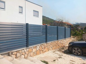 Stunning contemporary home with a driveway and scenic views of the surrounding hills.
