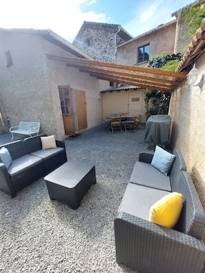 An outdoor seating area with wicker furniture and a pergola.