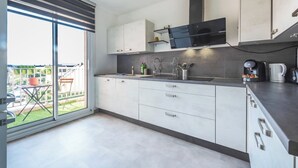 Eine moderne Küche mit großem Fenster, integriertem Herd und Kaffeemaschine.