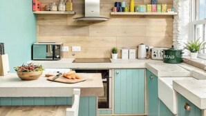 A kitchen with wooden cabinets, a countertop, and various kitchen items.