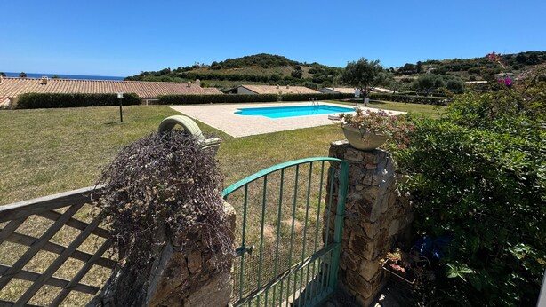 A swimming pool with a clear blue sky and a view of the sea in the background. - Terraced house with swimming pool, surrounded by nature, 250 meters from the sea (Marina, Tertenia)