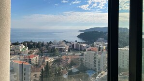 Paisagem costeira com edifícios, céu claro e vista para o mar.