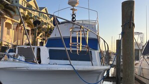A white boat docked at a marina with a clear sky.