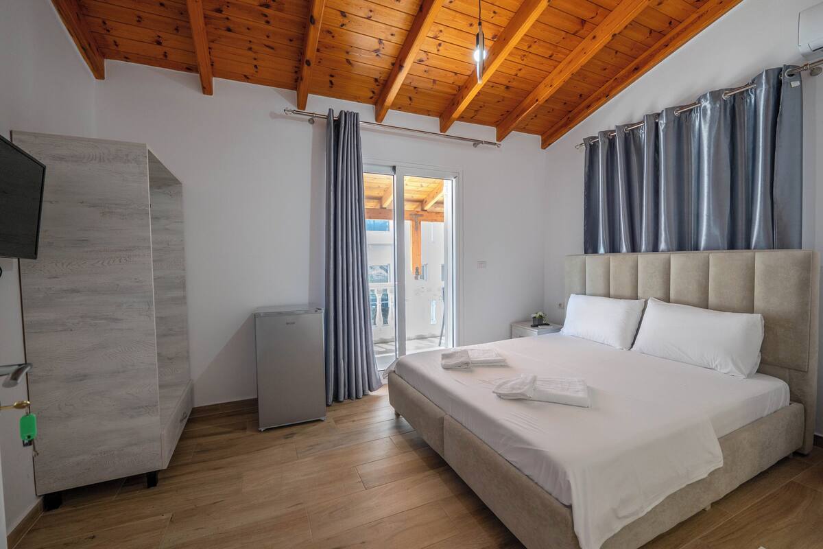 A bedroom with a bed, a wardrobe, and a television.