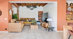 A living room with a sofa, coffee table, TV, and bookshelf.