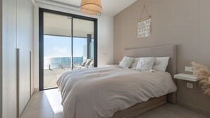 A bedroom with a large bed, a sliding glass door leading to a balcony, a hanging light fixture, and a wall-mounted shelf. - Bego a Sea View in Fuengirola (Fuengirola)