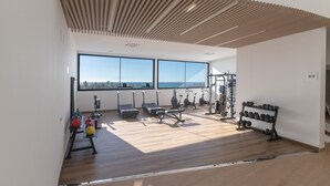 A modern gym with exercise equipment, large windows, and a wooden ceiling. - Bego a Sea View in Fuengirola (Fuengirola)