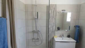 A modern bathroom with a glass shower enclosure, a white sink, and a mirror. - Les Terrasses d'Arutoli (Porto-Vecchio)