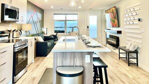 A modern kitchen with a central island, built-in appliances, and a large window.