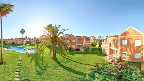 Un barrio residencial con casas, una piscina y jardines cuidados.