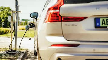 Un VUS blanc est garé à une borne de recharge.