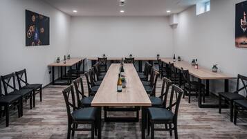 A conference room with a long table, multiple chairs, and potted plants.